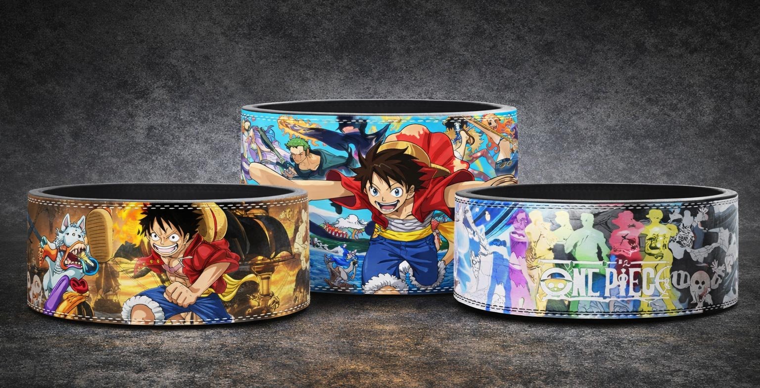 Three custom weightlifting belts featuring One Piece anime designs, including a light blue belt showing Monkey D. Luffy with his arms extended alongside Zoro and other characters, a fiery golden belt featuring Luffy in a fighting stance, and a black-and-white belt displaying colorful, glowing silhouettes of the Straw Hat crew members alongside the series logo.