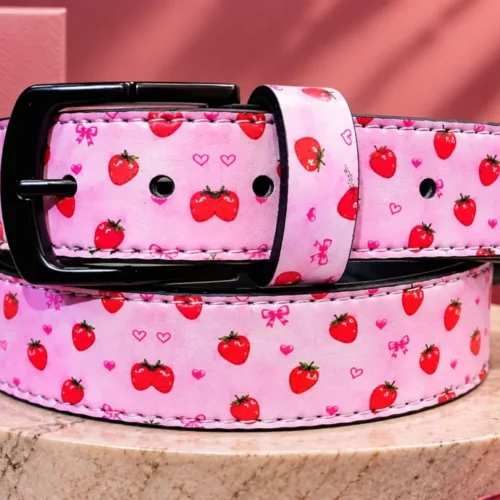 Pink strawberry-print leather pant belt with black buckle, coiled view