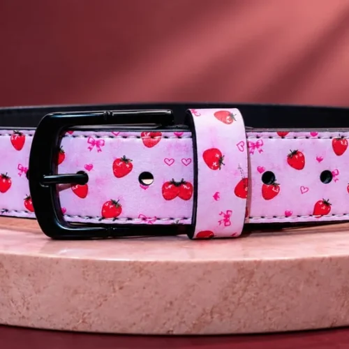 Pink strawberry-print leather pant belt with black buckle, front view